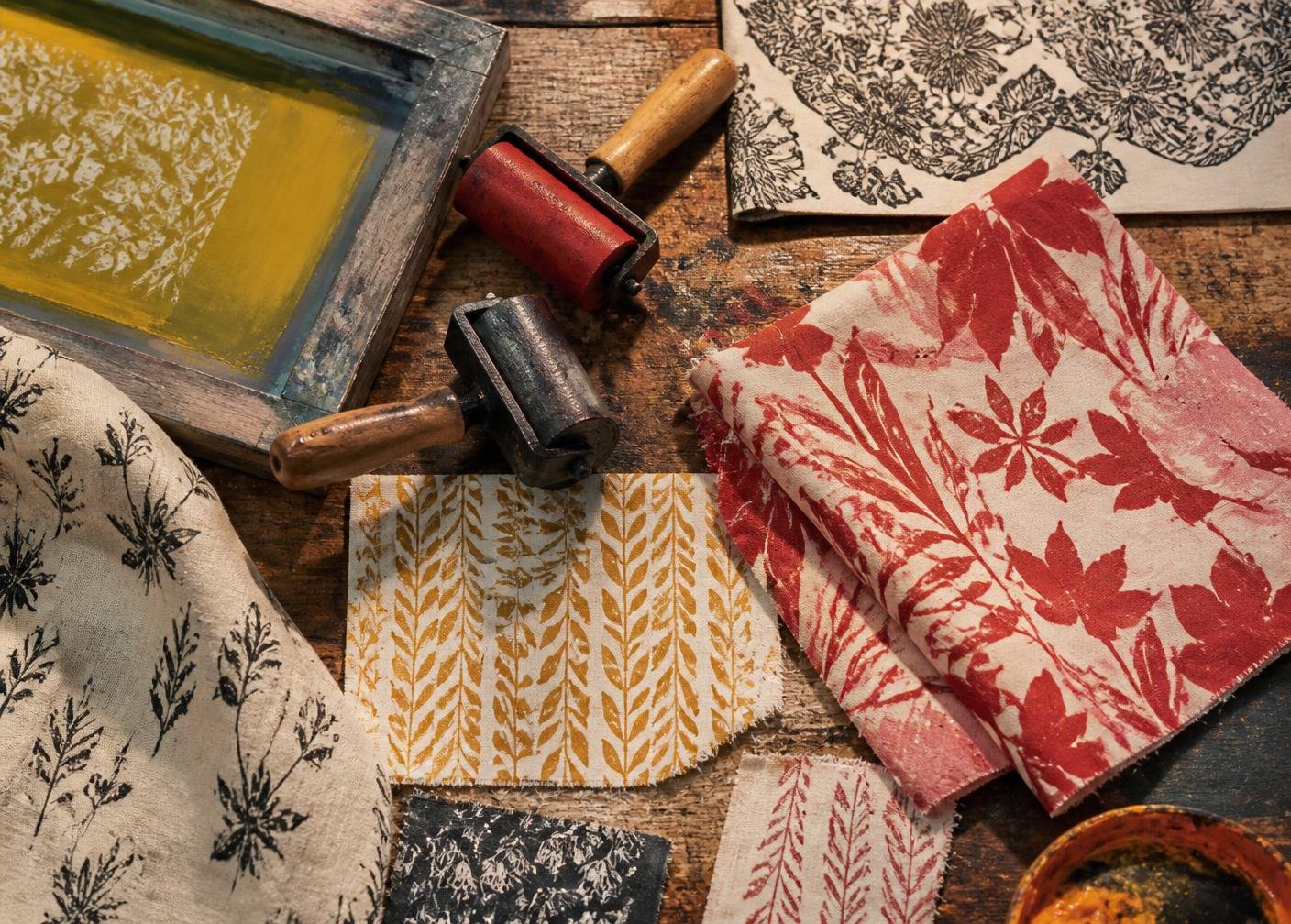 Block-printed textile samples and ink rollers on a studio table